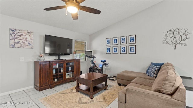 tiled living room featuring ceiling fan, vaulted ceiling, and a textured ceiling