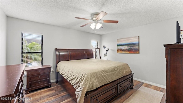 bedroom with multiple windows, dark hardwood / wood-style floors, and ceiling fan