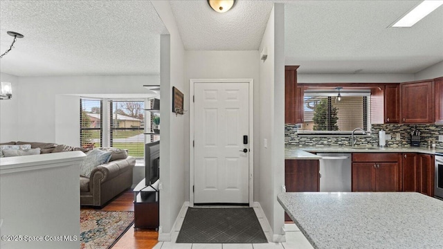 tiled entryway featuring sink and a notable chandelier