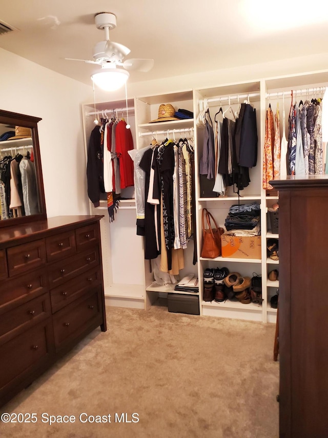 walk in closet featuring light colored carpet and ceiling fan