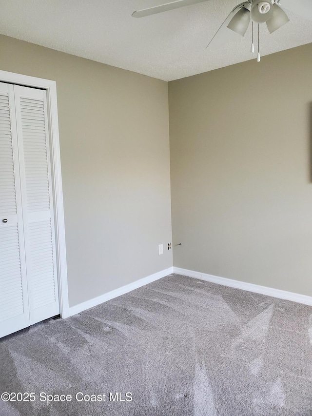 unfurnished bedroom featuring ceiling fan, a closet, and carpet