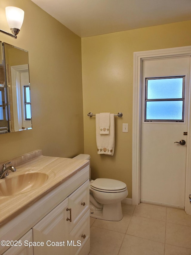 bathroom with tile patterned flooring, vanity, and toilet