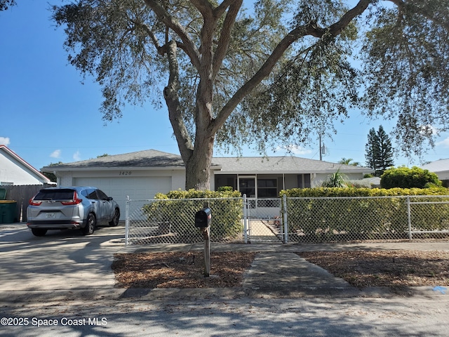 ranch-style house with a garage, a fenced front yard, a gate, and concrete driveway