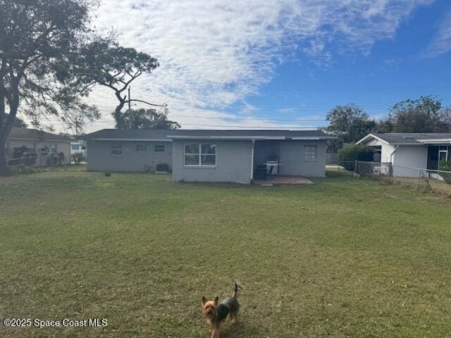 rear view of property with a lawn