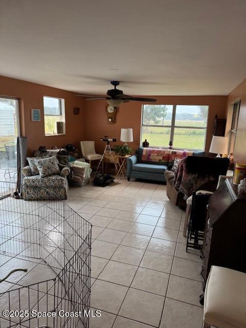 living room with ceiling fan and light tile patterned flooring