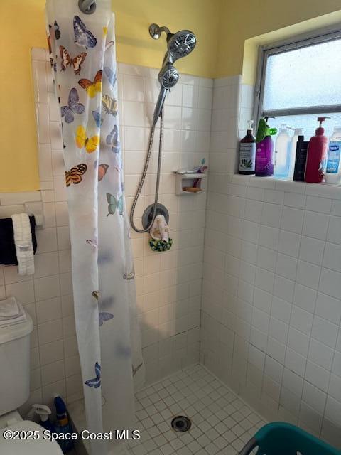 bathroom featuring toilet and a shower with shower curtain