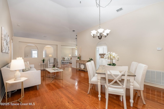 dining area featuring hardwood / wood-style floors and a notable chandelier