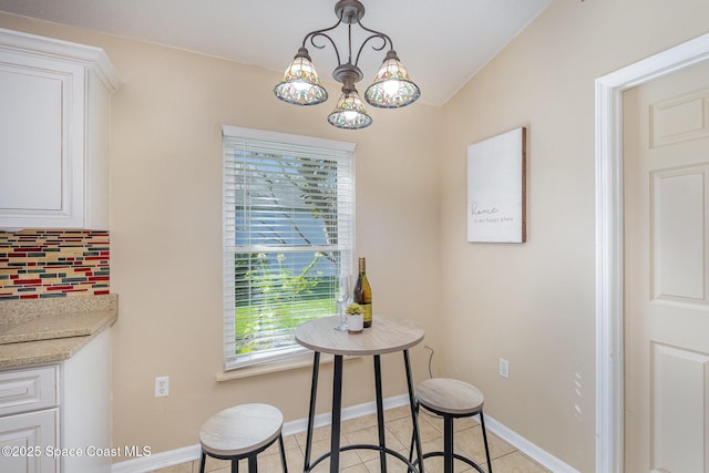 tiled dining room featuring a notable chandelier