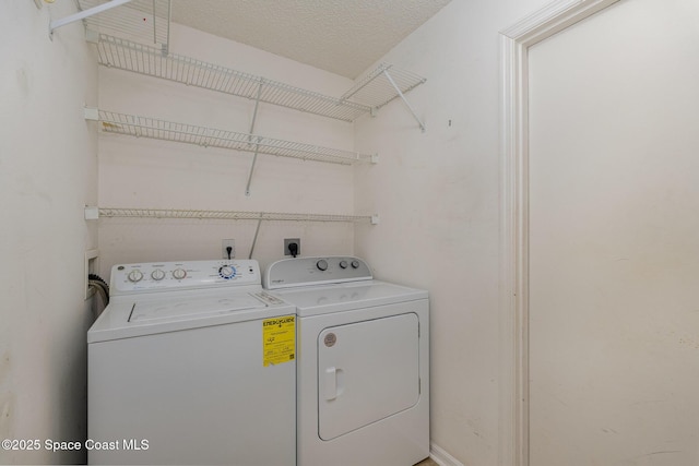 laundry area featuring a textured ceiling and washing machine and clothes dryer