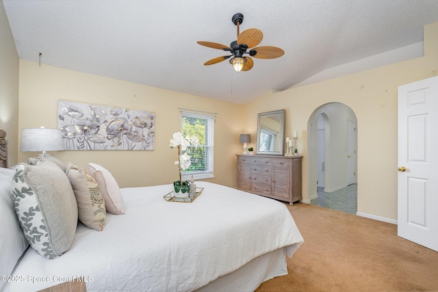 carpeted bedroom with lofted ceiling, ceiling fan, and a textured ceiling