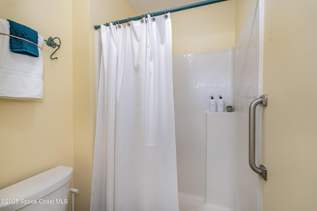 bathroom with a shower with curtain and toilet