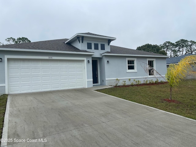 view of front of property with a garage and a front lawn