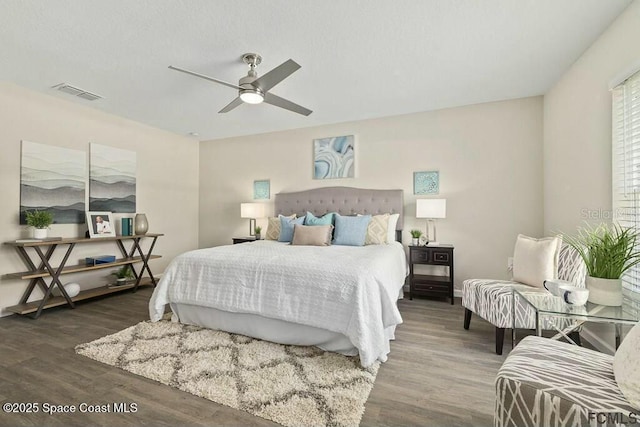 bedroom with dark hardwood / wood-style flooring and ceiling fan