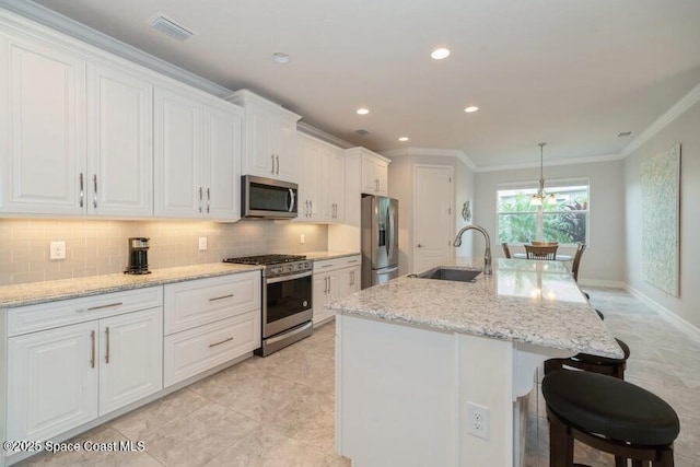 kitchen with sink, white cabinets, appliances with stainless steel finishes, and a center island with sink