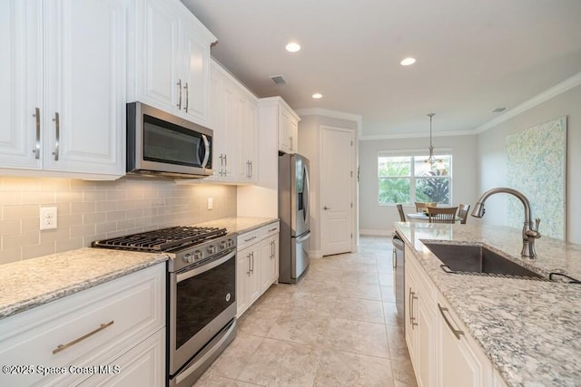 kitchen featuring light stone counters, decorative light fixtures, white cabinets, and stainless steel appliances