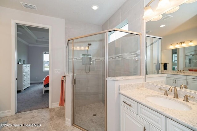 bathroom featuring a shower with door and vanity