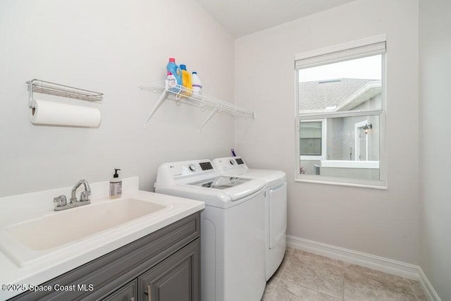 laundry area with sink, cabinets, washer and clothes dryer, and light tile patterned floors