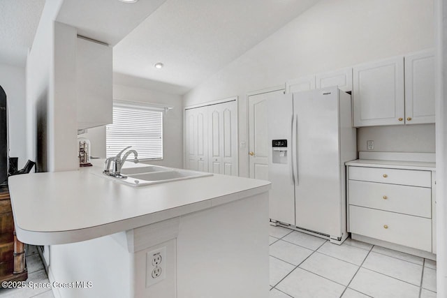 kitchen featuring white cabinetry, white refrigerator with ice dispenser, sink, kitchen peninsula, and lofted ceiling