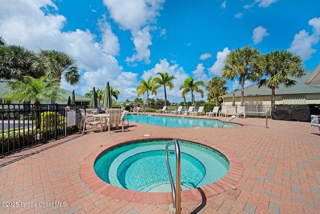 view of swimming pool with a patio area and a hot tub