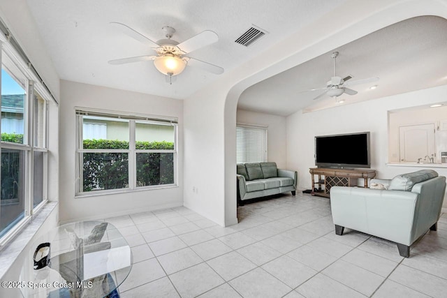 living room featuring ceiling fan, a healthy amount of sunlight, and light tile patterned floors