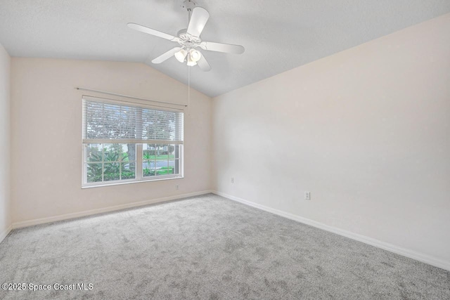 carpeted spare room featuring ceiling fan and lofted ceiling