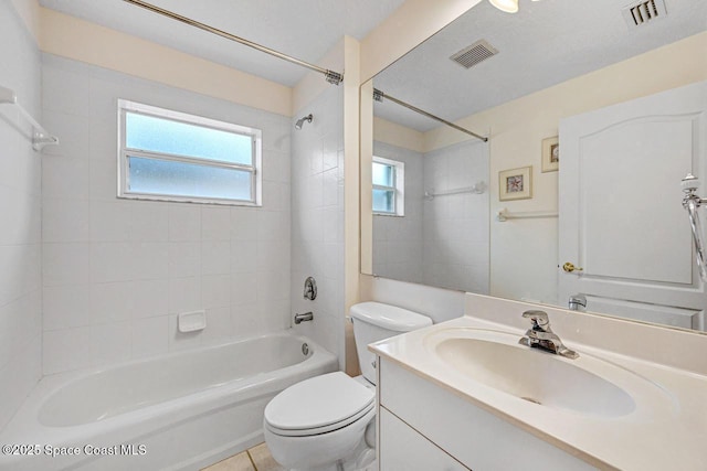 full bathroom with tiled shower / bath combo, toilet, and vanity