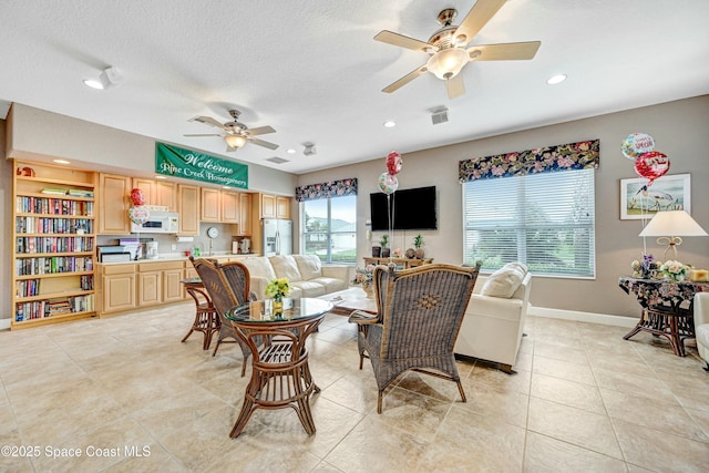 living room featuring a textured ceiling and ceiling fan