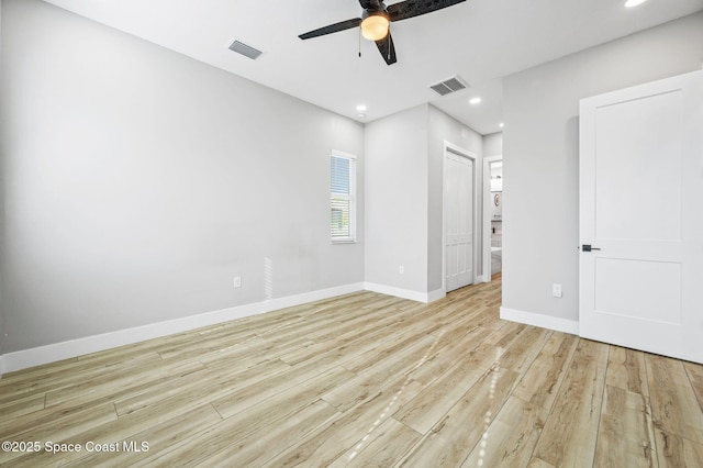 empty room with ceiling fan and light hardwood / wood-style floors