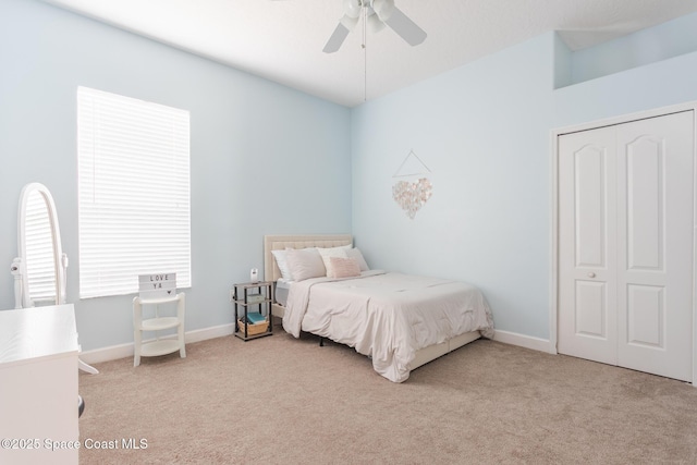 carpeted bedroom featuring ceiling fan and a closet