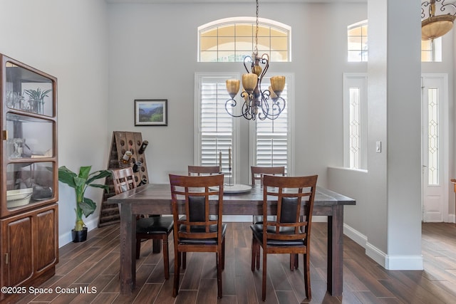 dining area with a high ceiling, a healthy amount of sunlight, and an inviting chandelier