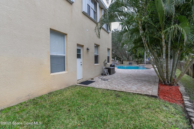 view of swimming pool featuring a yard and a patio area