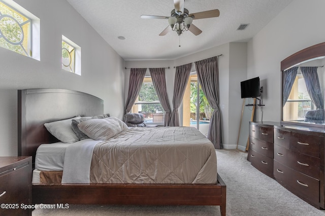 carpeted bedroom with access to exterior, a textured ceiling, and ceiling fan