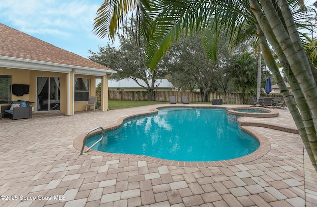 view of swimming pool featuring a patio and an in ground hot tub