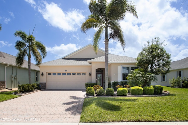 3489 Ahern Pl, Melbourne, FL 32940 - ranch-style home featuring a garage, stucco siding, a front yard, and decorative driveway