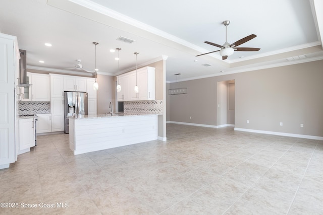 3489 Ahern Pl, Melbourne, FL 32940 - kitchen with stainless steel fridge with ice dispenser, a raised ceiling, open floor plan, a ceiling fan, and a peninsula