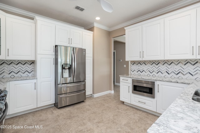 3489 Ahern Pl, Melbourne, FL 32940 - kitchen featuring visible vents, white cabinets, stainless steel fridge, and decorative backsplash