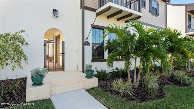 entrance to property with a balcony and stucco siding