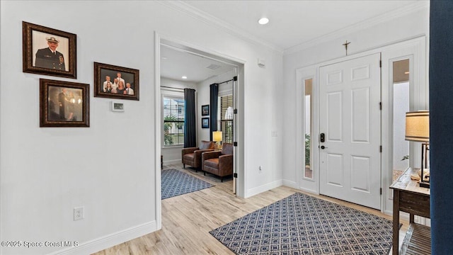 foyer entrance with crown molding and light hardwood / wood-style floors