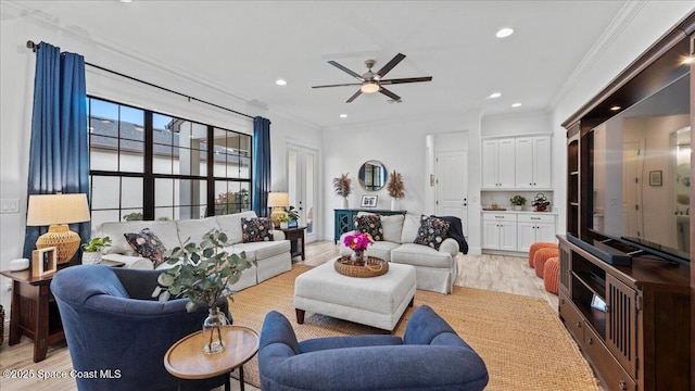 living room with light hardwood / wood-style flooring, ornamental molding, and ceiling fan