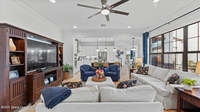 living room featuring recessed lighting, a ceiling fan, visible vents, light wood finished floors, and crown molding