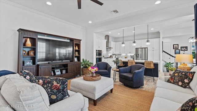 living room with ceiling fan, ornamental molding, sink, and light hardwood / wood-style floors