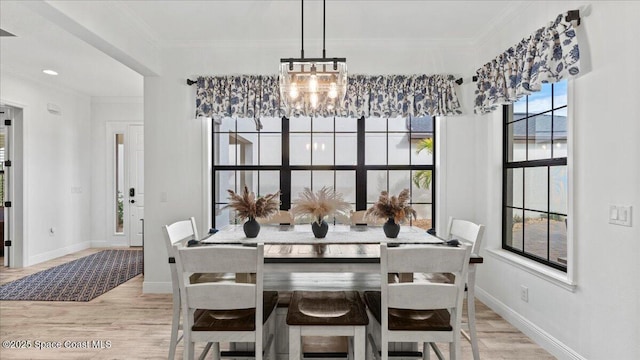 dining room featuring baseboards, a notable chandelier, wood finished floors, and crown molding