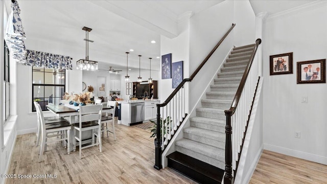 dining room featuring crown molding, sink, and light hardwood / wood-style floors