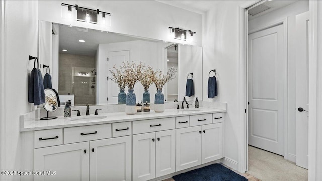 bathroom with double vanity, a stall shower, and a sink