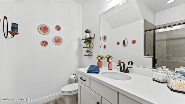 full bathroom featuring toilet, a tile shower, vanity, wood finished floors, and baseboards