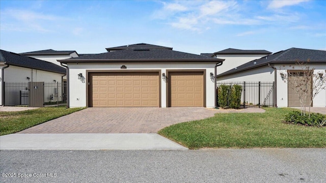 view of front of home featuring an attached garage, fence, decorative driveway, stucco siding, and a front lawn