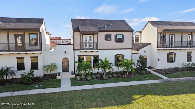 view of front of home with a front yard and a balcony