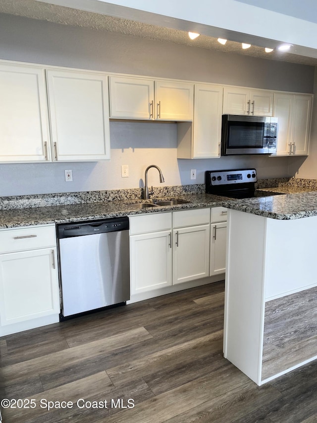 kitchen with stainless steel appliances, sink, white cabinets, and dark hardwood / wood-style floors