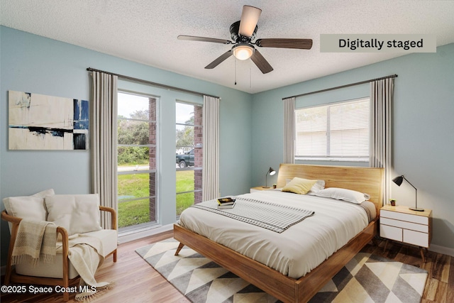 bedroom with multiple windows, ceiling fan, and light hardwood / wood-style flooring