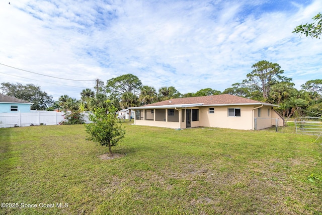 rear view of property with a lawn